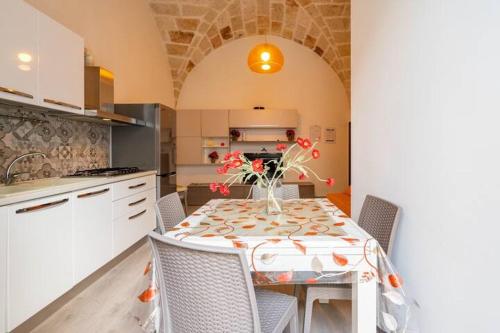 a kitchen with a table with a vase of flowers on it at B&b SAN LORENZO in Conversano