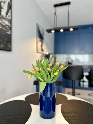 a blue vase with flowers sitting on a table at Blisko Gór Szyndzielnia in Bielsko-Biala