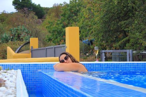 a woman in a swimming pool wearing sunglasses at Gemütliches Ferienhaus in El Rosario mit Privatem Pool und Panoramablick in El Rosario