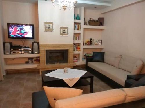 sala de estar con sofá y TV en Family friendly house nearby the sea, en Agia Paraskevi