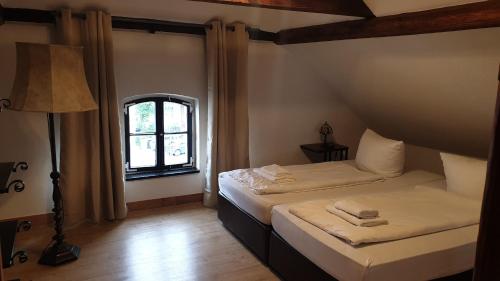 een slaapkamer met 2 bedden en een raam bij Gästehaus Zu Herrenwiesen in Heidelberg