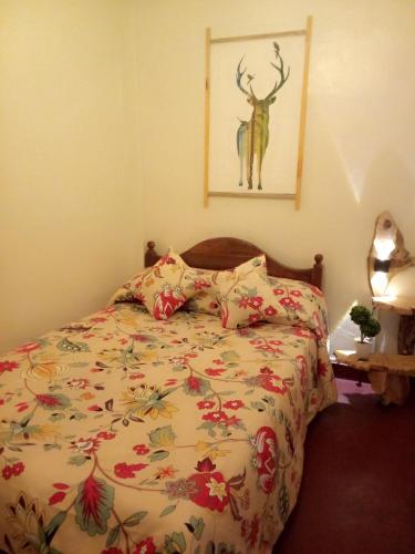 a bedroom with a bed with a deer painting on the wall at Green Heart Homestay in Nuwara Eliya