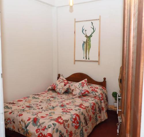 a bedroom with a bed with a deer picture on the wall at Green Heart Homestay in Nuwara Eliya