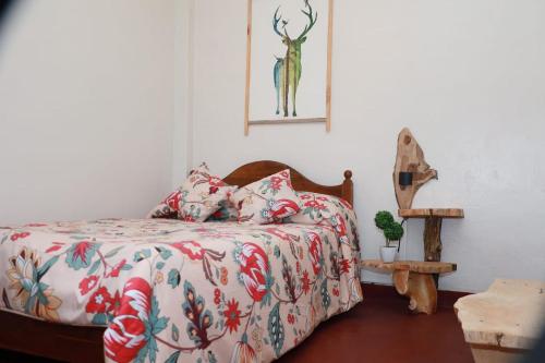 a bedroom with a bed with a floral comforter at Green Heart Homestay in Nuwara Eliya