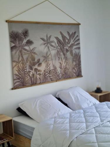 - une chambre avec une peinture de palmiers sur le mur dans l'établissement Petit coin de paradis au bord du Minaouet, à Trégunc