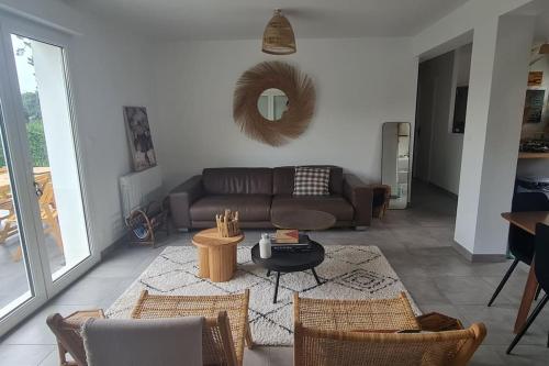 un salon avec un canapé et une table dans l'établissement Petit coin de paradis au bord du Minaouet, à Trégunc