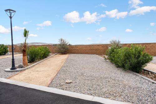 a driveway with gravel and a wall and a street light at RV71-Lot- Paradise RV Park in Desert Hot Springs