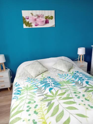 - une chambre dotée d'un lit avec un mur bleu dans l'établissement Duplex face océan T2 + mezzanine à Bretignolles sur mer, à Bretignolles-sur-Mer