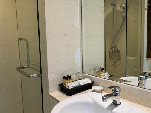 a bathroom with a sink and a mirror at Silom Forest Exclusive Residence in Bangkok