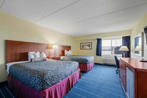 Cette chambre comprend deux lits et un bureau. dans l'établissement Relax Inn, à Alexandria