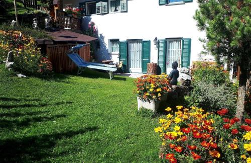a person sitting in the yard of a house with flowers at Wohnung in Pufels mit Gepflegtem Garten in Bulla