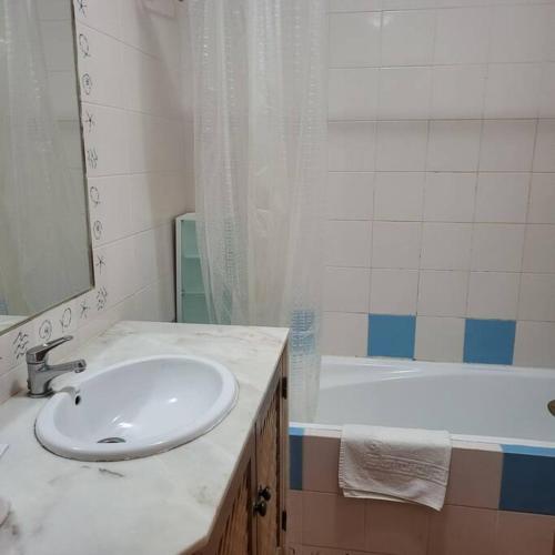 a bathroom with a sink and a bath tub at Tavira Garden Pool Apartment Algarve in Tavira