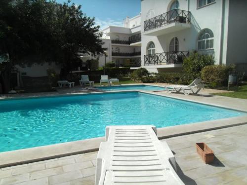 a swimming pool in front of a building at Tavira Garden Pool Apartment Algarve in Tavira
