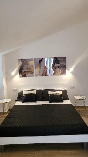 1 dormitorio con 1 cama negra grande y 2 mesas en Etna sicula, en San Giovanni la Punta