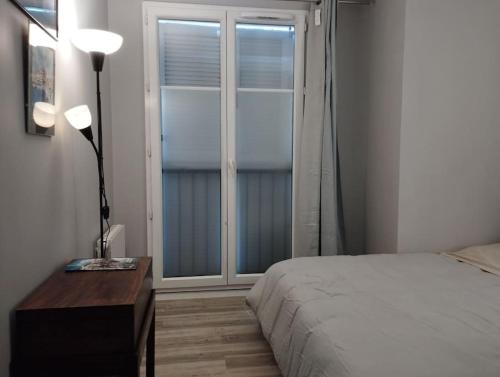 a bedroom with a bed and a large window at Appartement calme proche Paris in Villiers-sur-Marne