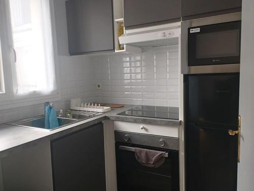 a kitchen with a sink and a stove top oven at Appartement calme proche Paris in Villiers-sur-Marne