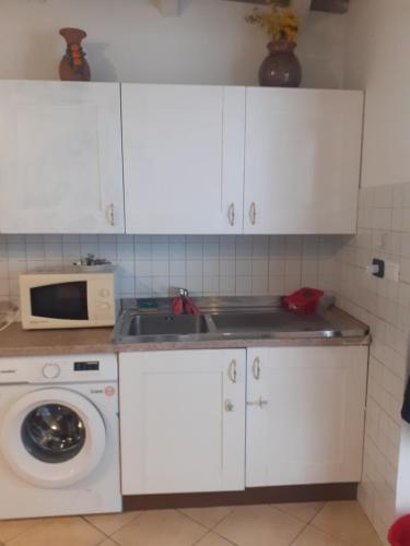 a kitchen with a sink and a washing machine at Appartamento Vacanze Malù in Moneglia