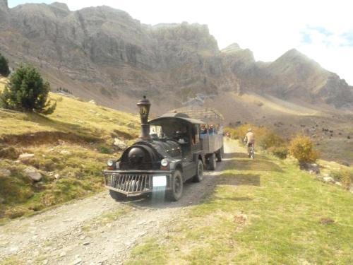 an old train is driving down a dirt road at Hotel Sabocos in Panticosa