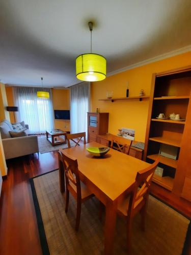 comedor y sala de estar con mesa y sillas en Apartamento en Beiramar, en O Grove