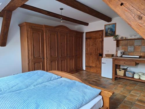 a bedroom with a blue bed and wooden cabinets at Apartmány Ve starém pivovaru in Malešov