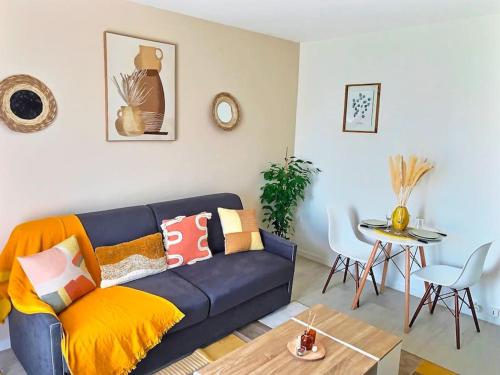 sala de estar con sofá azul y mesa en b- Appartement lumineux proche velizy bis, en Meudon