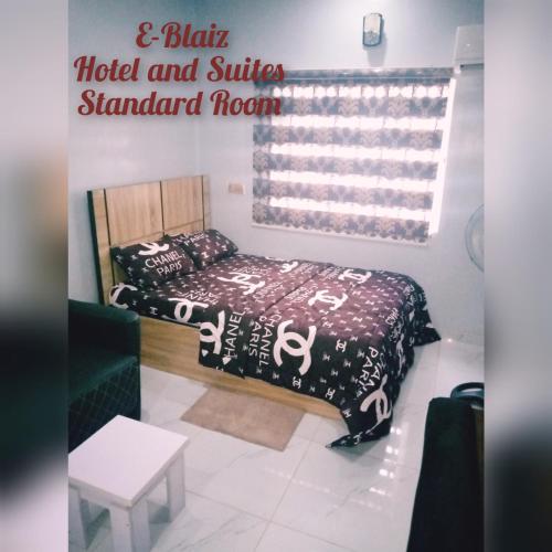 Habitación con cama y cartel que lee habitación estándar hotel y suites en E-Blaiz Hotel & Suites, en Magboro-Akeran