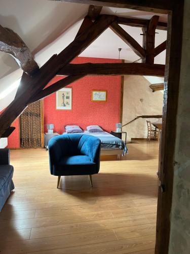 ein Schlafzimmer mit einem Bett und einem blauen Stuhl in der Unterkunft Les Belles Fontaines in Bierry-les-Belles-Fontaines