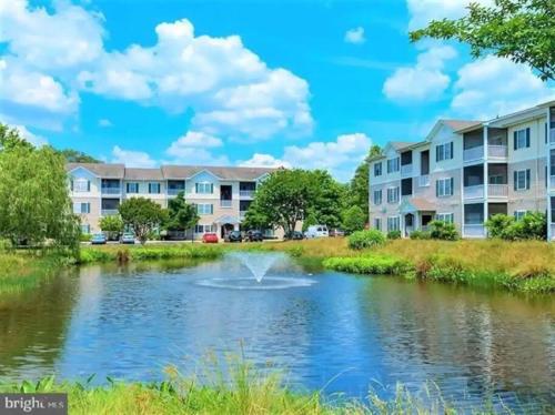 a fountain in a pond in front of apartment buildings at Family perfect getaway 2 bedroom apartment in Rehoboth Beach