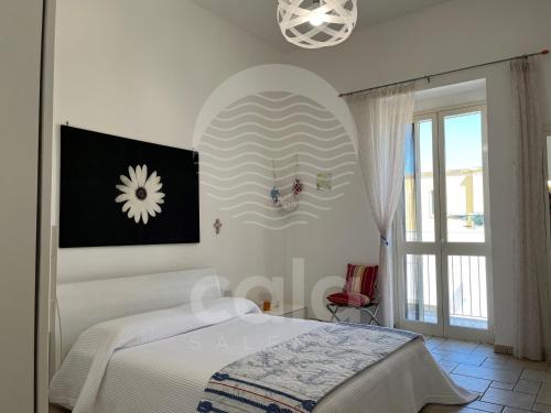um quarto branco com uma cama e uma janela em Il Timone em Porto Cesareo