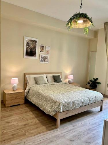 a bedroom with a bed and two lamps and a chandelier at Favola Guesthouse Affittacamere in Nettuno
