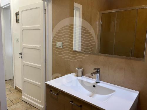 W łazience znajduje się biała umywalka i lustro. w obiekcie Il Timone w mieście Porto Cesareo