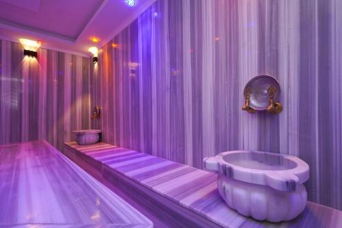un bagno viola con vasca e lavandino di Kleopatra Arsi Hotel a Alanya