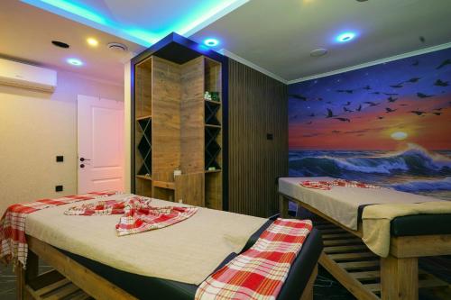 2 Betten in einem Zimmer mit Wandgemälde in der Unterkunft Kleopatra Arsi Hotel in Alanya