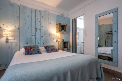 a bedroom with a large bed and a mirror at Hotel La Roseraie in Fouras
