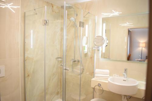 y baño con ducha y lavamanos. en Gartenhotel Kloepferkeller, en Eibiswald