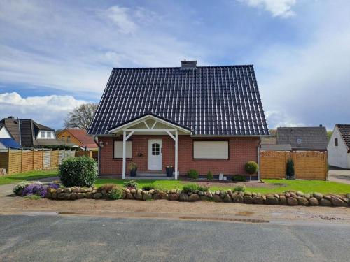 una casa de ladrillo rojo con techo negro en Ferienhaus Kallies - Dat grote Huus en Bornhöved