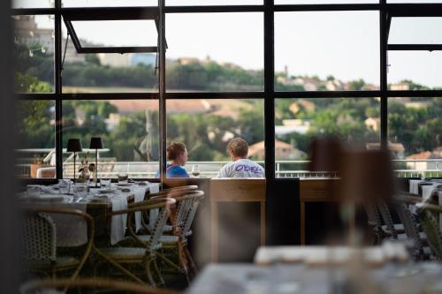 Due persone sedute in un ristorante che guardano fuori dalla finestra di Locanda Fontezoppa a Civitanova Alta