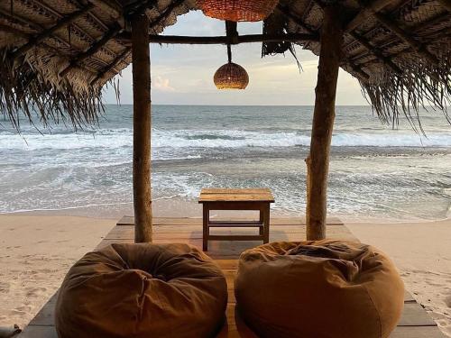 a tent on the beach with a table and the ocean at Cinnabar Resort in Tangalle