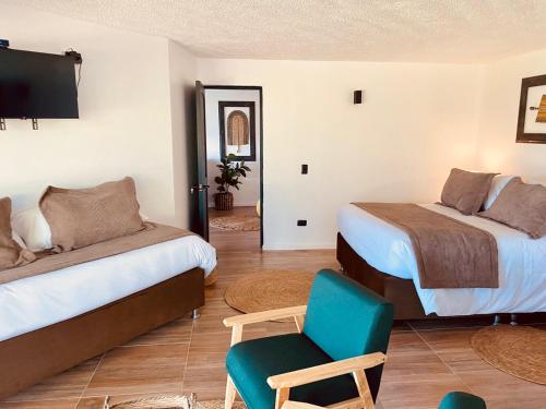 una habitación de hotel con 2 camas y una silla en Hotel Marina del Lago , Colbún, en Rota