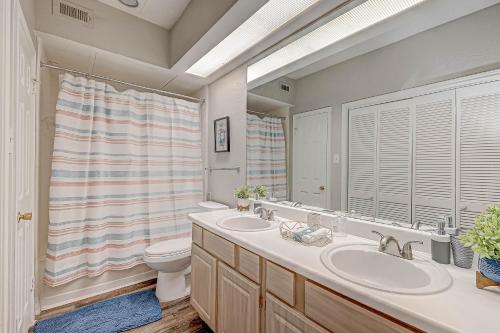 a bathroom with two sinks and a toilet and a window at Med Center Urban living in Houston