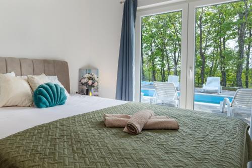 a bedroom with a bed with two towels on it at New Villa Nadalina in Lovreć
