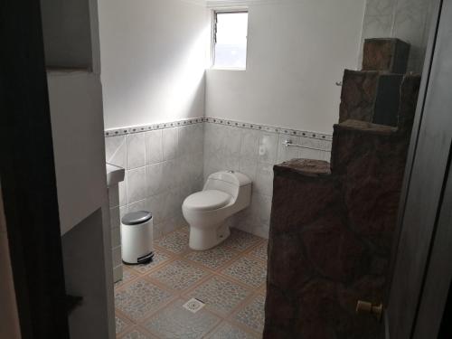 a small bathroom with a toilet and a window at San Pedro Domos in San Pedro de Atacama