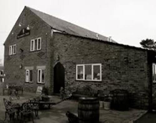 a large brick building with a large door and windows at Brandreth Barn in Burscough