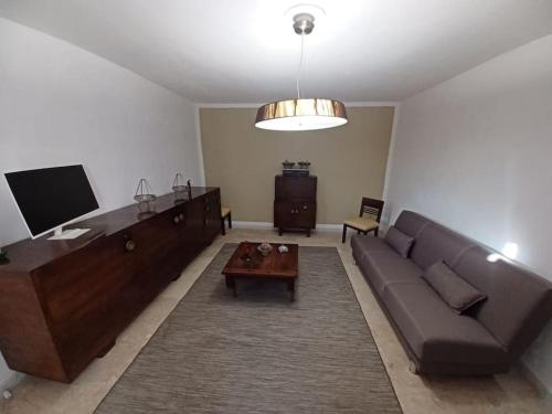 a living room with a couch and a table at La Casa Rossa -Dimora di campagna in Montechiaro D'acqui
