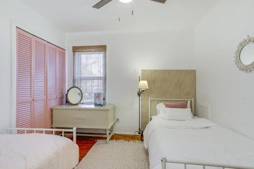 - une chambre blanche avec 2 lits et un miroir dans l'établissement Pet-Friendly Smith Island Cottage with Golf Cart!, à Ewell