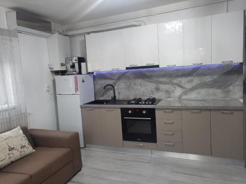 a kitchen with a sink and a stove and a couch at Alina apartaments in Sibiu