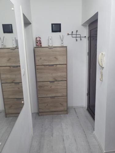 Zimmer mit Holzkommoden und einem Schrank in der Unterkunft Alina apartaments in Sibiu