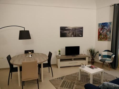a living room with a table and a tv at Sunset Ortigia-locazione turistica in Syracuse