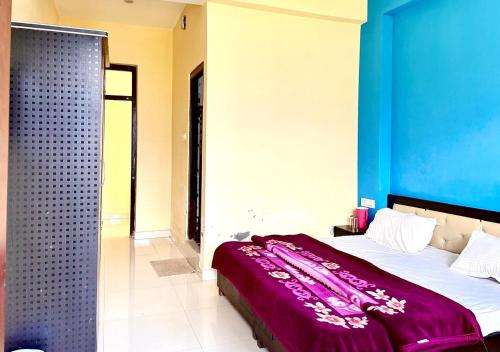 a bedroom with a bed with a purple blanket on it at Sristhi Homestay view point Naddi in Dharamshala