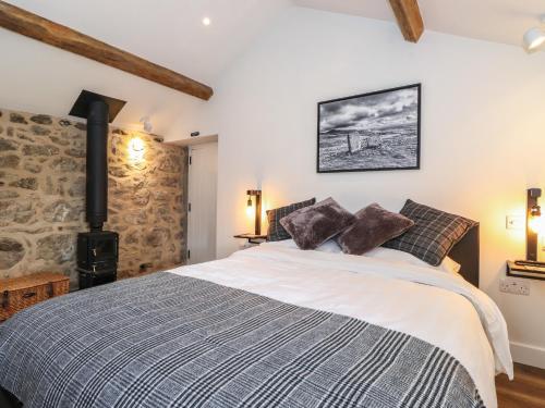 ein Schlafzimmer mit einem Bett und einer Steinmauer in der Unterkunft Skylight Retreat in Carnforth